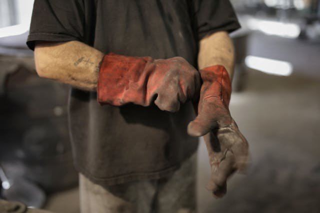 someone putting on dirty red gloves