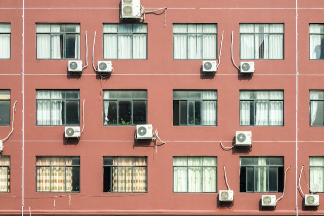 outside pink wall of a building with air conditioners in full view